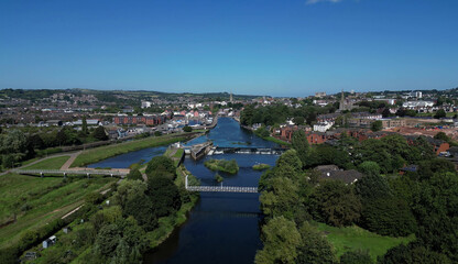 Fototapeta na wymiar Exeter, South Devon, England: DRONE VIEWS: The River Exe (centre); Exeter Ship Canal (left); Trews Weir and Suspension Bridge; Exeter Quays and the city of Exeter skyline. 