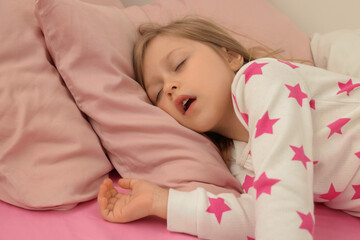 Little girl snoring while sleeping in bed