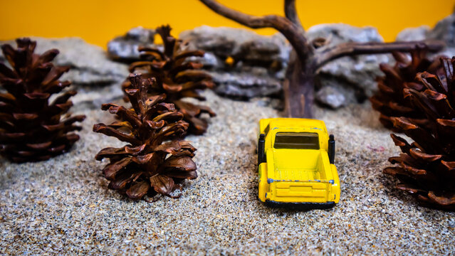 Minahasa, Indonesia : December 2022, the toy car among the pine cones - Powered by Adobe