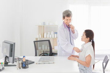 Fototapeta premium doctor talk with female patient about disease symptom, doctor use stethoscope listening to chest of patient, adult health check up in happiness hospital