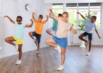 Obraz premium Portrait of smiling children practicing sport dance in modern dance hall