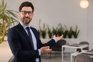 Happy real estate agent indoors. Space for text