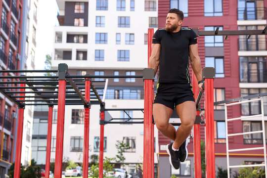 Man training on parallel bars at outdoor gym
