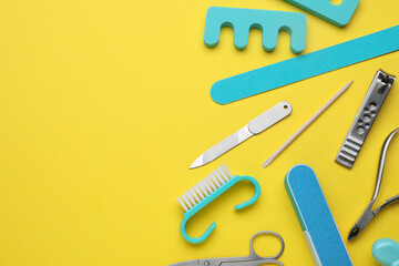 Set of pedicure tools on yellow background, flat lay. Space for text