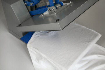 Printing logo. Heat press with t-shirt on white table
