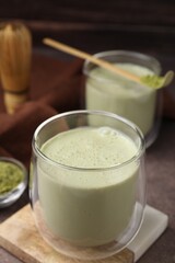 Glass of tasty matcha smoothie on brown table, closeup. Space for text