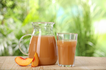 Tasty peach juice and fresh fruit on wooden table outdoors