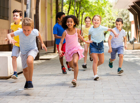 Happy children running in race and laughing outdoors at sunny day