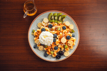 Waffles with mixed fruit, cream topping and honey