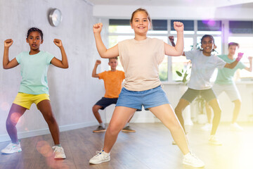 Young boys and girls performing dance with his mates in studio during rehearsal.