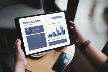 A close-up of an anonymous businesswoman analyzing statistical business reports on her tablet PC at...