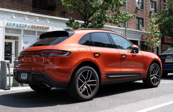 New York City, USA - August 05, 2023: 2023 Porsche Macan T SUV Ruby red car rear and passenger side view, parked