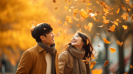 落ちてくる紅葉を見上げて幸せそうな日本人カップル