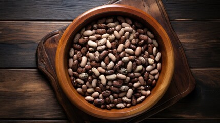 Fototapeta premium Top view of assorted beans in a wooden bowl on a wooden table