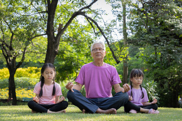 Grandfather and granddaughter experience tranquil among shadyness of the trees.