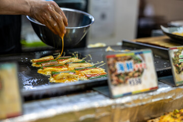 Woman preparing the food in Korea market of Osaka, Japan