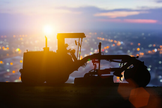 Bulldozer and grader silhouettes in construction zone: Heavy equipment at work site, Grader Loader in action on highway, Construction Machinery and Workers on a Renovation Project in Heavy Industry.