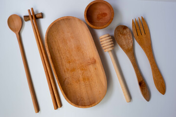 Wooden cutlery, wooden bowl and wooden plate. Cozy arrangement rustic style. isolated white background.