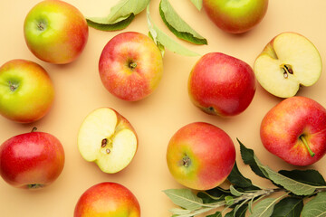 Ripe red apples with green leaves on beige background. Top view.