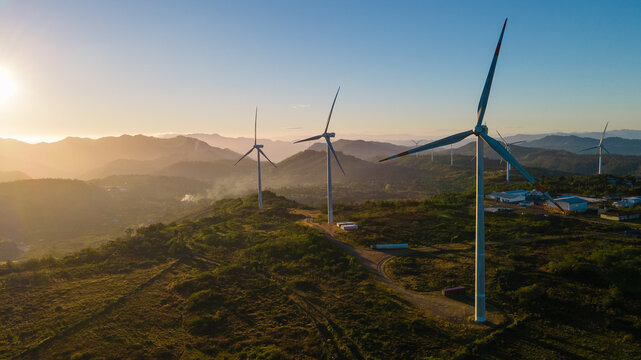 Beautiful sunrise over a park of wind turbines and with some fog