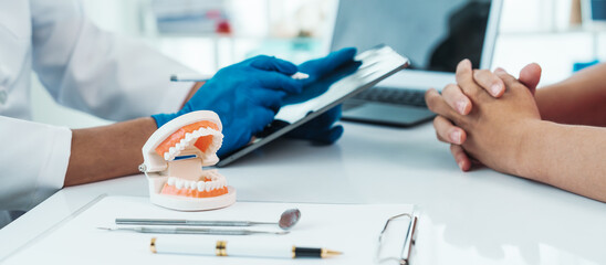Teeth treatment talk, dentist and patient engaging in a discussion with a model, dental consultation exemplifies patient-centered dentistry, emphasizing personalized care and informed choices.