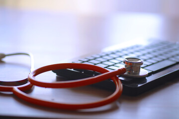 Doctor`s desk in the clinic's office. Stethoscope, test tubes, laptop, prescriptions on the table.