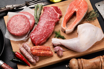 Various raw meat and fish. Steaks, sausages, salmon, chicken and spices