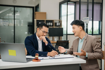 Business and lawyers discussing contract papers with brass scale on desk in office. Law, legal services, advice,  justice and law concept ..