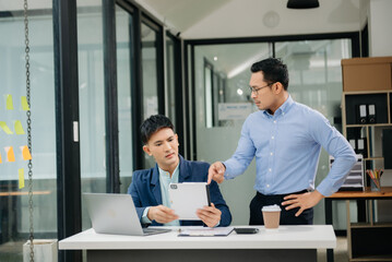 Furious two Asian businesspeople arguing strongly after making a mistake at work in modern office