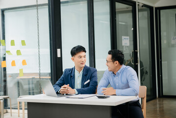 Male discussing new project with business colleague. Young man talking with young man in office.