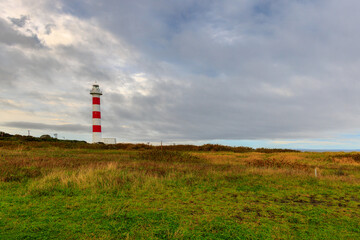 Fototapeta na wymiar Coastal lighthouse with red and white stripes on Rishiri Island in Hokkaido