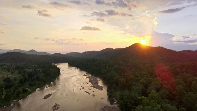 Aerial view river passing through Forest in India. Drone shot neat Maoist forest in Jharkhand, India. Sunset over dense forest with river and dramatic sky. Sunrise in forest in India
