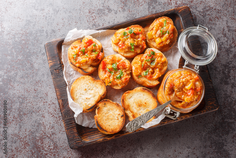 Wall mural Sandwiches with homemade spread from eggplant, zucchini, tomatoes, onions, bell peppers and garlic. Horizontal top view from above