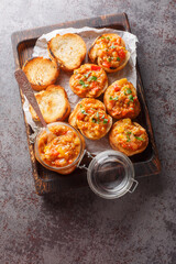 Grilled Vegetable spread or dip prepared with eggplant, tomato, pepper, onion and garlic close-up on a wooden board on the table. Vertical top view from above