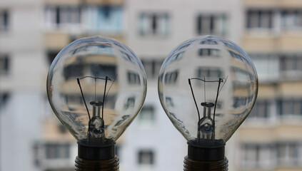 Two Electric Light Lamp With Multi Storey Apartment House On A Background As An Illustration Of Electricity Efficient 
