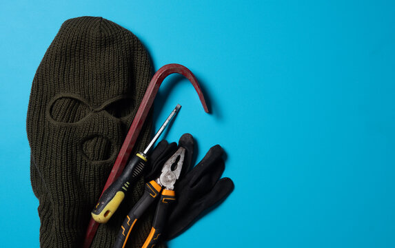 Beige knitted balaclava, gloves,screwdriver and Crowbar,Collection of tools and equipment for theft,flat lay. Space for text - Powered by Adobe