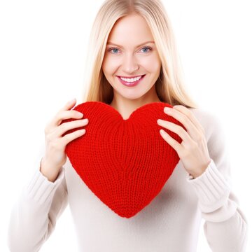 Happy young woman wigth knitted heart in hands