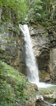 Sibli Waterfall impressive cascade falling from an impressive high rock with Mariengrotte in a quiet and hidden place in the forest with the St. Mary watches over it