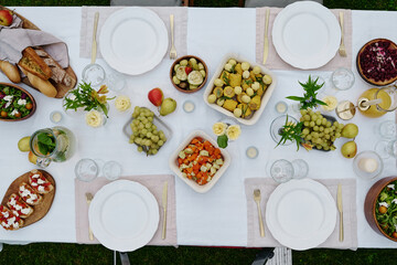 Top view of large table served with variety of appetizing homemade food such as vegetable stew, salad, sandwiches, fresh fruits and bread