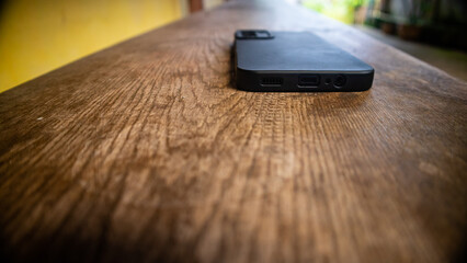 black smartphone on a wooden bench