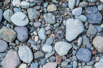 The stones were laid on the ground in the garden as a background. Background blur. Pebble stones background. Crushed stone on the seashore. Selective focus on object. 
