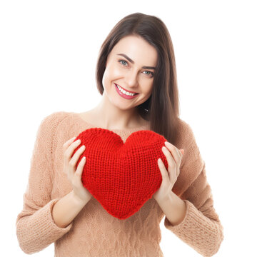 Happy young woman wigth knitted heart in hands
