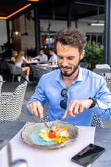 Man eating chicken fillet with potato and carrot puree in the restaurant