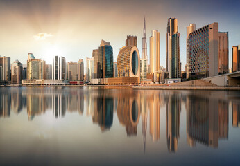 Dubai skyline with reflection at dramatic sunset with sun in United Arab Emirates - 643918896