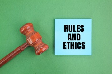 judge's gavel and colored paper with the words rules and ethics. the concept of compliance or work...