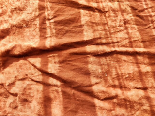 Abstract background and texture of crumpled brown satin fabric. Texture, pattern, frame, copy space