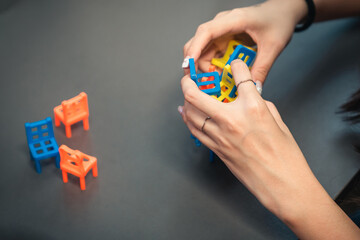 creative stacking skillful hands balancing colorful tiny chairs