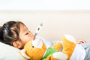 Sick kid. Mother parent checking temperature of her sick daughter with digital thermometer in mouth, child laying in bed taking measuring her temperature for fever and illness, healthcare - obrazy, fototapety, plakaty