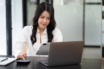 Women are using calculators to calculate office income.