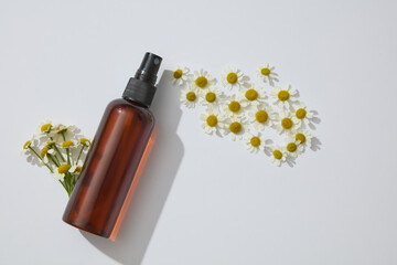 Many white flowers arranged with unbranded spray bottle. Chamomilla (Matricaria chamomilla) is a...
